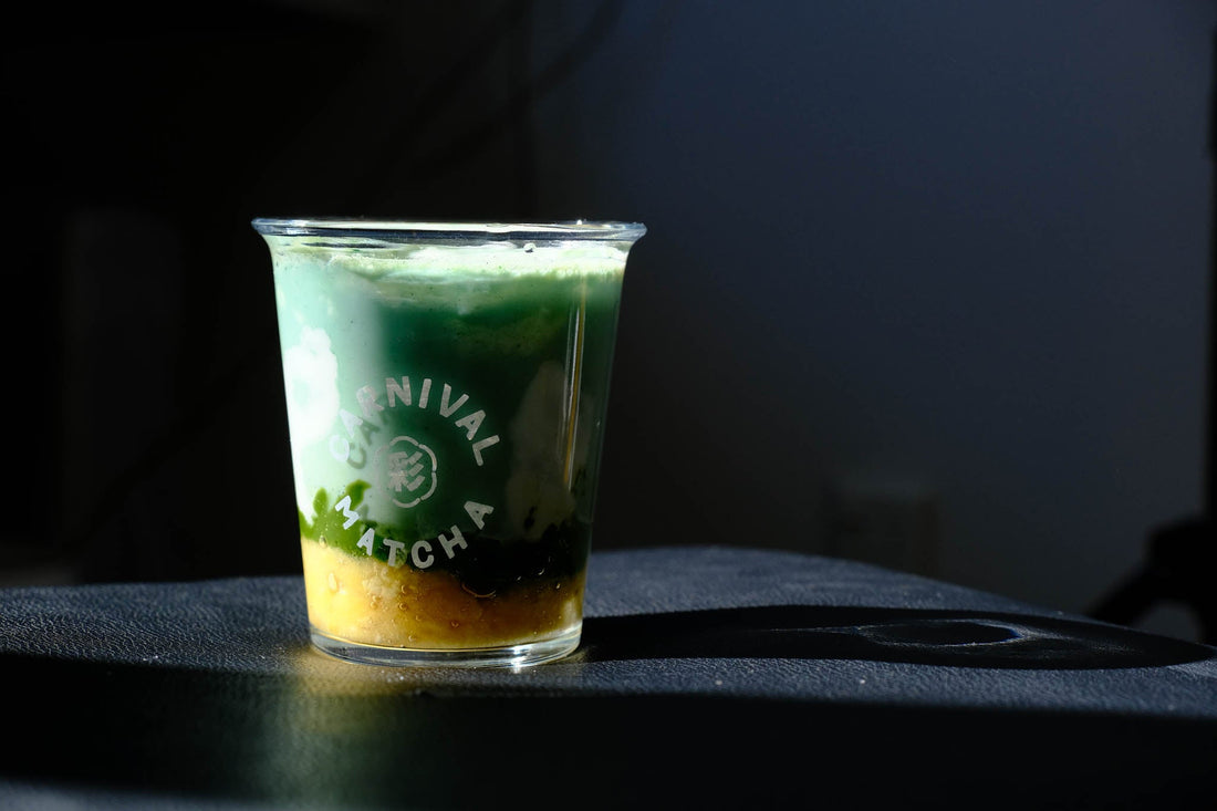 Spirited Away inspired matcha drink with layered matcha pudding, spirulina soy milk, banana, and a fluffy yoghurt cloud, served in a glass with dreamy green and white layers, evoking Studio Ghibli vibes of blue skies and calm fields